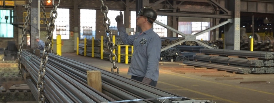 A McDonald Steel employee stood in front of a stack of hot rolled steel